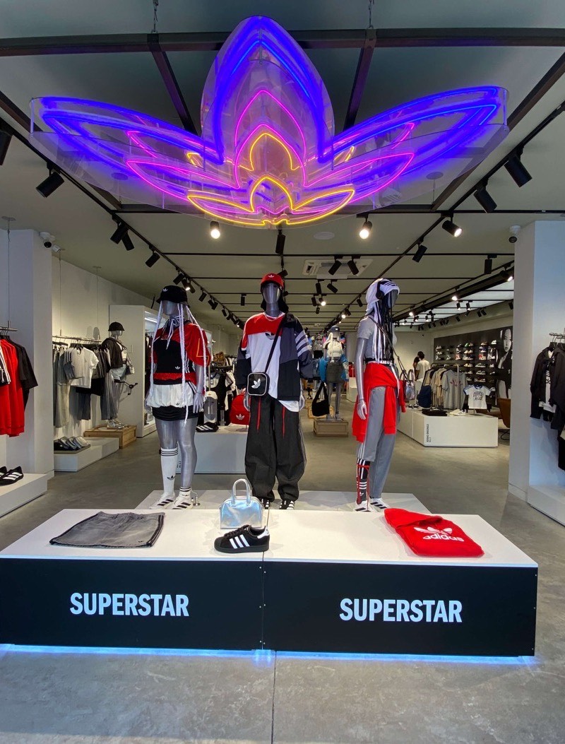 The Adidas store in Uruguay, a neon trefoil above the Superstar plinth.