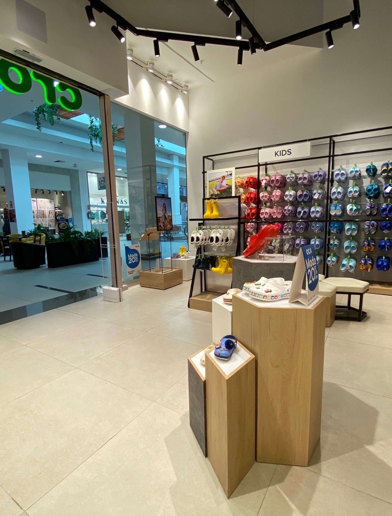 The Crocs store in Peru, footwear walls behind timber display plinths.